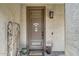 Inviting front door with decor, plants, and a welcoming exterior light fixture at 18120 W Cassia Way, Goodyear, AZ 85338