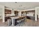 Spacious kitchen features dark wood cabinets, granite counters, stainless appliances and large center island at 18120 W Cassia Way, Goodyear, AZ 85338