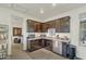 Functional kitchenette features dark wood cabinetry, stainless steel appliances, and tile flooring at 18120 W Cassia Way, Goodyear, AZ 85338
