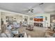 Spacious living room with a ceiling fan, neutral decor, and a large flat-screen TV at 18120 W Cassia Way, Goodyear, AZ 85338