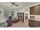 Office space with large windows, desk, bookcase, and partial view of the kitchenette at 18120 W Cassia Way, Goodyear, AZ 85338