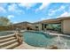 The backyard features a sparkling pool with a rock waterfall and desert landscaping at 18120 W Cassia Way, Goodyear, AZ 85338