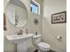Charming half bathroom features a white pedestal sink, oval mirror, and decorative accents at 18120 W Cassia Way, Goodyear, AZ 85338