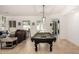 Spacious living room with tile floors, plantation shutters, and a stylish pool table at 1834 E Scorpio Pl, Chandler, AZ 85249
