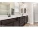 Modern bathroom featuring a double vanity with dark cabinets and a large mirror at 19726 W Woodlands Ave, Buckeye, AZ 85326