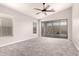 Bright bedroom with neutral walls, new carpet, ceiling fan, and sliding glass doors to backyard at 19726 W Woodlands Ave, Buckeye, AZ 85326