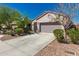 Single-story home with a gray two-car garage door, desert-landscaped yard, and concrete driveway at 19726 W Woodlands Ave, Buckeye, AZ 85326