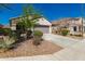 Single-story home with landscaped front yard, long driveway, and an attached two-car garage at 19726 W Woodlands Ave, Buckeye, AZ 85326