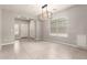 Open living space with tile floors and an attractive chandelier to complement the neutral walls at 19726 W Woodlands Ave, Buckeye, AZ 85326