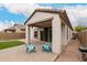 A covered patio features stylish pavers and two blue chairs, perfect for outdoor relaxation at 19726 W Woodlands Ave, Buckeye, AZ 85326