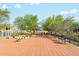 Spacious backyard patio with brick pavers, mature trees, and multiple seating areas at 20041 W Pasadena Ave, Litchfield Park, AZ 85340