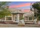 Inviting home exterior featuring a tiled roof, arched entryway, and large rock in the landscaped front yard at 20041 W Pasadena Ave, Litchfield Park, AZ 85340