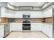 Modern kitchen featuring stainless steel appliances, ample white cabinetry and stylish tile backsplash at 20041 W Pasadena Ave, Litchfield Park, AZ 85340