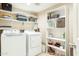 Functional laundry room with washer, dryer, storage shelves, and ample space for organization at 20041 W Pasadena Ave, Litchfield Park, AZ 85340