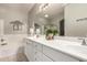 Bathroom with double sinks, long vanity, garden tub, and decorative mirror at 21152 W Sunrise Ln, Buckeye, AZ 85396