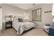 Bedroom features neutral tones, shuttered window, side table, and sitting chair at 21152 W Sunrise Ln, Buckeye, AZ 85396