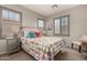 Bright bedroom with plantation shutters, colorful pillows, side tables, and a bedside lamps at 21152 W Sunrise Ln, Buckeye, AZ 85396