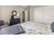 Comfortable bedroom featuring a blue dresser and patterned bedding, with a door slightly ajar to the next room at 21152 W Sunrise Ln, Buckeye, AZ 85396
