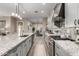 Spacious kitchen boasts granite countertops, stainless steel appliances, gray cabinets, and a subway tile backsplash at 21152 W Sunrise Ln, Buckeye, AZ 85396