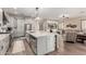Open kitchen with a large island, stainless steel appliances, and gray cabinets, flowing into the adjacent living room at 21152 W Sunrise Ln, Buckeye, AZ 85396
