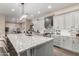 Open kitchen features a large island with seating, stainless steel appliances, gray cabinets, and flows into the dining area at 21152 W Sunrise Ln, Buckeye, AZ 85396