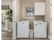 Bright laundry room with white washer and dryer, overhead cabinets, and a window for natural light at 21152 W Sunrise Ln, Buckeye, AZ 85396