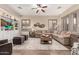 Spacious living room with hardwood floors, a large sectional sofa, and custom built-in entertainment center at 21152 W Sunrise Ln, Buckeye, AZ 85396