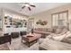Inviting living room featuring hardwood floors, a large sofa, custom built-ins, and a stylish ceiling fan at 21152 W Sunrise Ln, Buckeye, AZ 85396