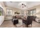 Cozy living room featuring hardwood floors, comfortable seating, plantation shutters and a ceiling fan at 21152 W Sunrise Ln, Buckeye, AZ 85396