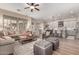 Open living room featuring a ceiling fan, hardwood floors, a comfortable sofa, and adjacent access to the kitchen at 21152 W Sunrise Ln, Buckeye, AZ 85396