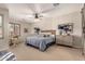 Spacious main bedroom featuring a ceiling fan, a large bed, and shutters at 21152 W Sunrise Ln, Buckeye, AZ 85396