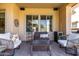 Cozy covered patio featuring comfortable seating, a coffee table, and windows into the home at 21152 W Sunrise Ln, Buckeye, AZ 85396