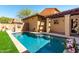 Refreshing backyard pool with cool turquoise water, surrounded by a stone patio and green artificial turf at 21152 W Sunrise Ln, Buckeye, AZ 85396