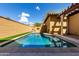 Sparkling pool in a private backyard with a sun-themed wall decoration and artificial turf at 21152 W Sunrise Ln, Buckeye, AZ 85396