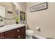 Charming powder room featuring a dark wood vanity, decorative mirror, and modern fixtures at 21152 W Sunrise Ln, Buckeye, AZ 85396