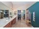 Bright bathroom featuring double sinks, walk-in closet, and shower with eye-catching tile accents at 2116 E Beautiful Ln, Phoenix, AZ 85042