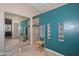 Modern bathroom with walk-in shower, teal accent wall, and mirrored closet doors at 2116 E Beautiful Ln, Phoenix, AZ 85042
