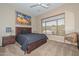 Cozy bedroom features a wooden bed frame, ceiling fan, and large window at 2116 E Beautiful Ln, Phoenix, AZ 85042
