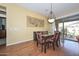 Light-filled dining room with wood floors and a glass sliding door to the outdoor patio at 2116 E Beautiful Ln, Phoenix, AZ 85042