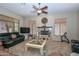 A cozy living room with a fireplace, carpet, and bright windows at 2116 E Beautiful Ln, Phoenix, AZ 85042