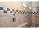 Close up of shower with tiled walls and unique dark granite tile accents at 2116 E Beautiful Ln, Phoenix, AZ 85042