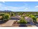 Aerial shot of a desert home and neighborhood featuring a large yard, garage, and sunset views at 21470 E Orchard Ln, Queen Creek, AZ 85142