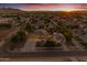 Dusk aerial view of a home in a residential area with beautiful sunset views over the Phoenix Mountains at 21470 E Orchard Ln, Queen Creek, AZ 85142
