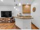 Entertainment area features custom cabinetry, a bar with seating, and hardwood flooring at 21470 E Orchard Ln, Queen Creek, AZ 85142