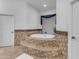 Elegant bathroom featuring a raised, mosaic-tiled platform leading to a luxurious soaking tub at 21470 E Orchard Ln, Queen Creek, AZ 85142