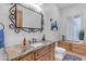 Stylish bathroom with a decorative mirror, a granite countertop, and a wooden cabinet at 21470 E Orchard Ln, Queen Creek, AZ 85142