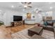 Open-concept living area with wooden floors and a large TV at 21470 E Orchard Ln, Queen Creek, AZ 85142