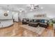 Spacious living room featuring hardwood floors, leather sofa and a ceiling fan at 21470 E Orchard Ln, Queen Creek, AZ 85142