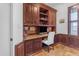 Cozy home office with custom wood cabinetry, granite countertops, and window with plantation shutters at 21470 E Orchard Ln, Queen Creek, AZ 85142