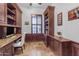 Home office featuring custom wood shelving, a built-in desk, and plantation shutters at 21470 E Orchard Ln, Queen Creek, AZ 85142